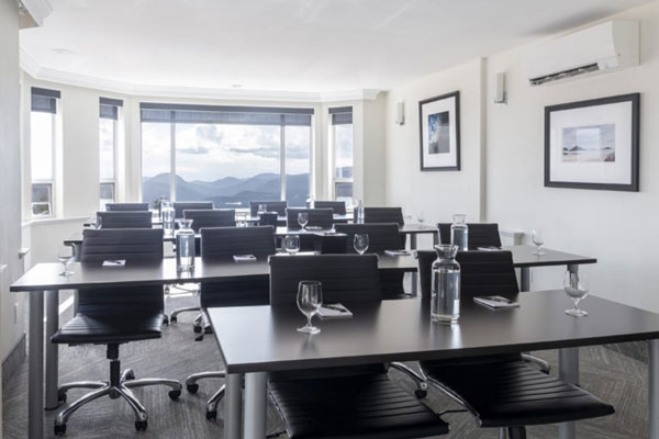 Line up of tables ready for a meeting in the Baker room.