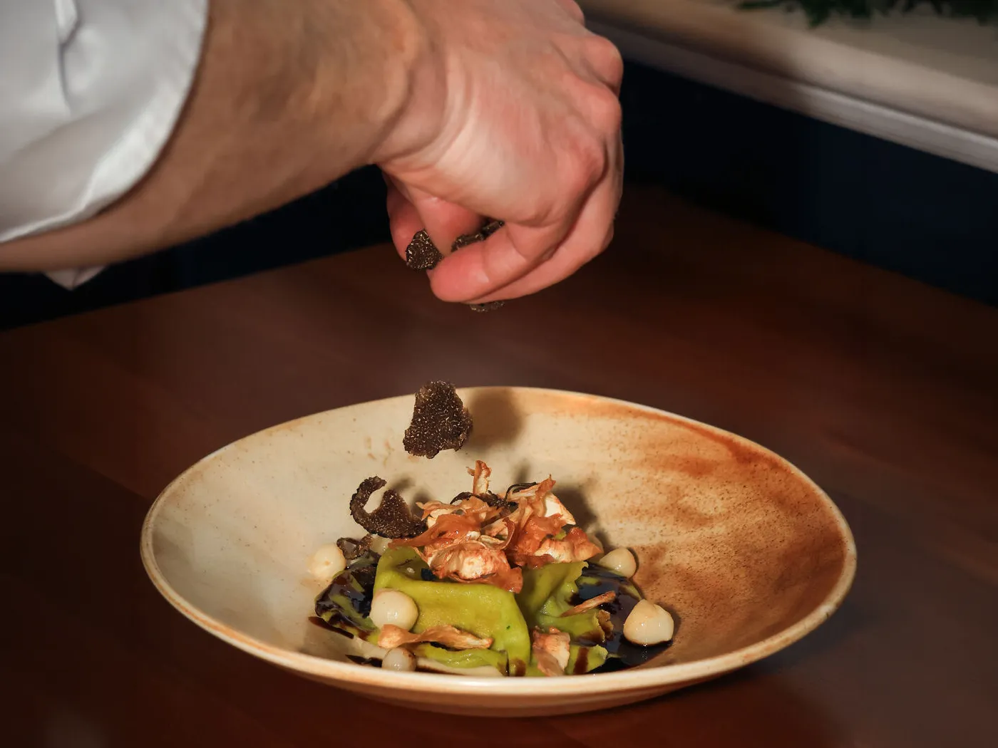Chef placing finishing touches on plate.